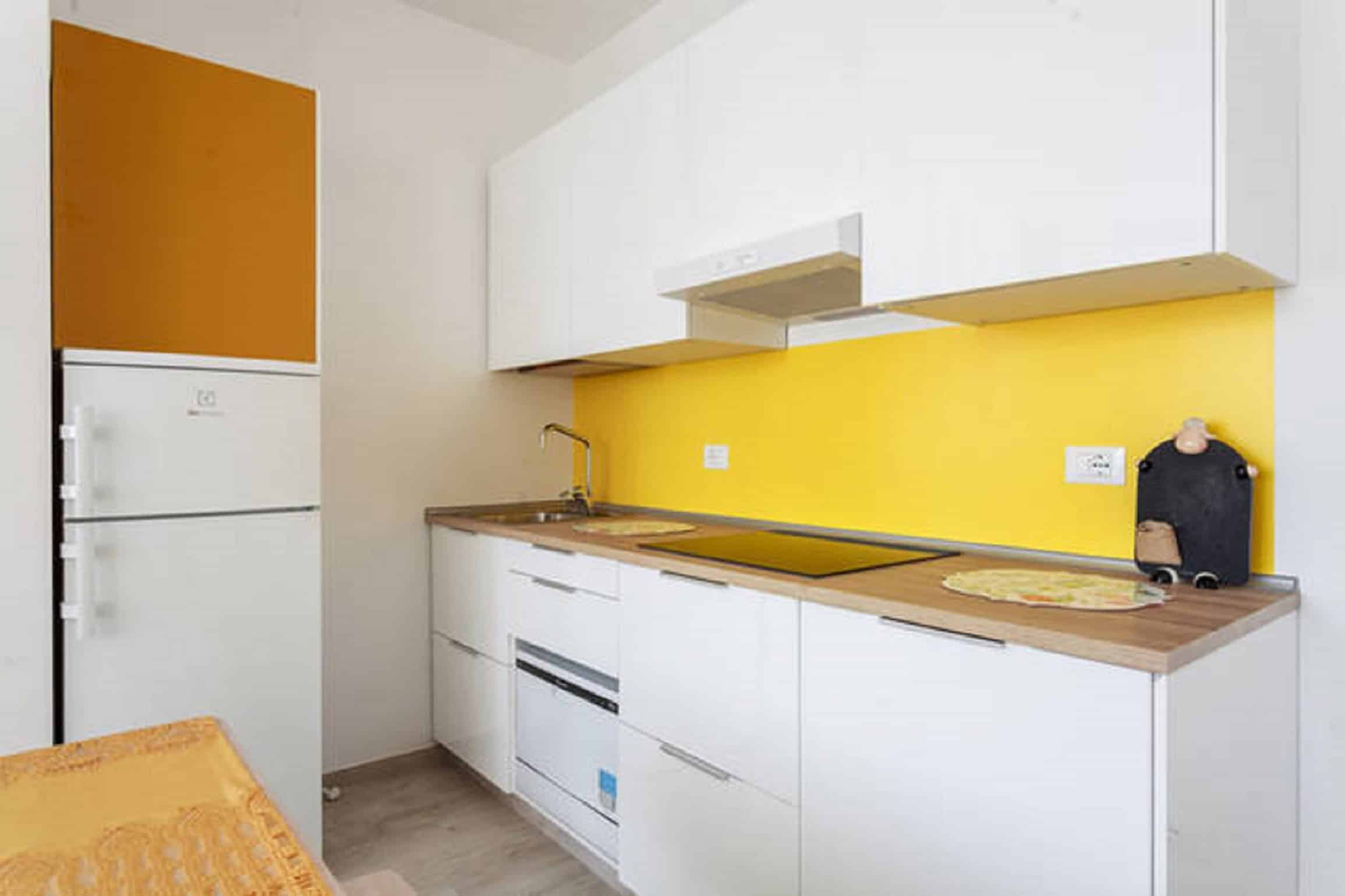 Riva Reno Apartment Modern kitchen with yellow accents - Riva Reno Apartment
